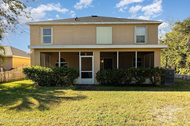 rear view of house featuring a sunroom, a yard, and central AC