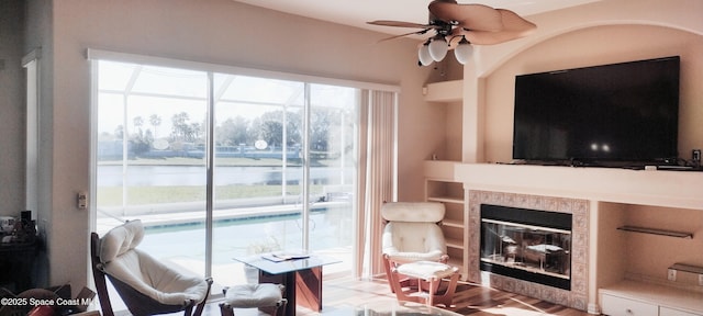 living room featuring ceiling fan and a fireplace