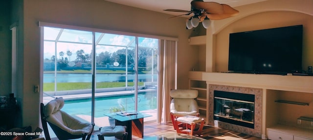 living room with ceiling fan and a fireplace