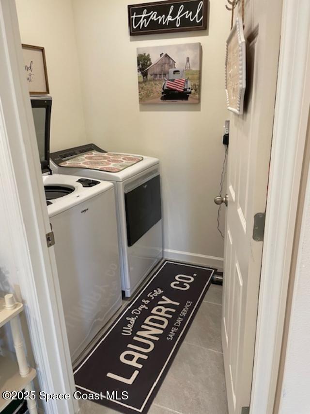 laundry area featuring separate washer and dryer and light tile patterned floors