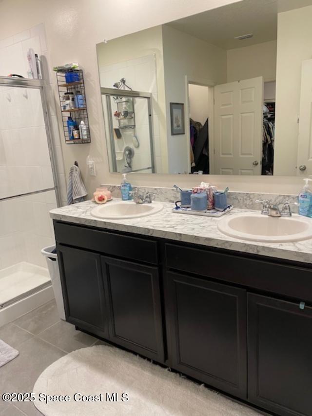 bathroom featuring tile patterned floors, vanity, and a shower with door