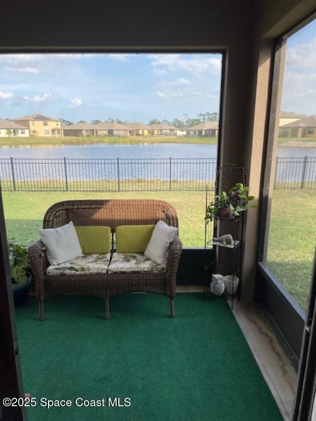 sunroom featuring a water view