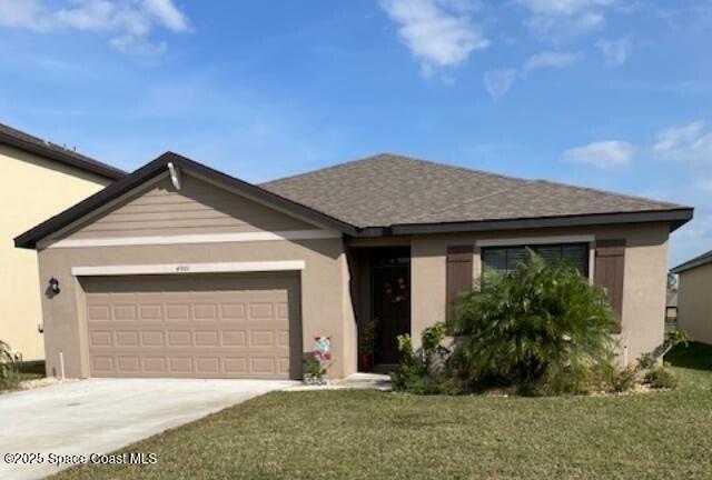 ranch-style home featuring a garage and a front lawn