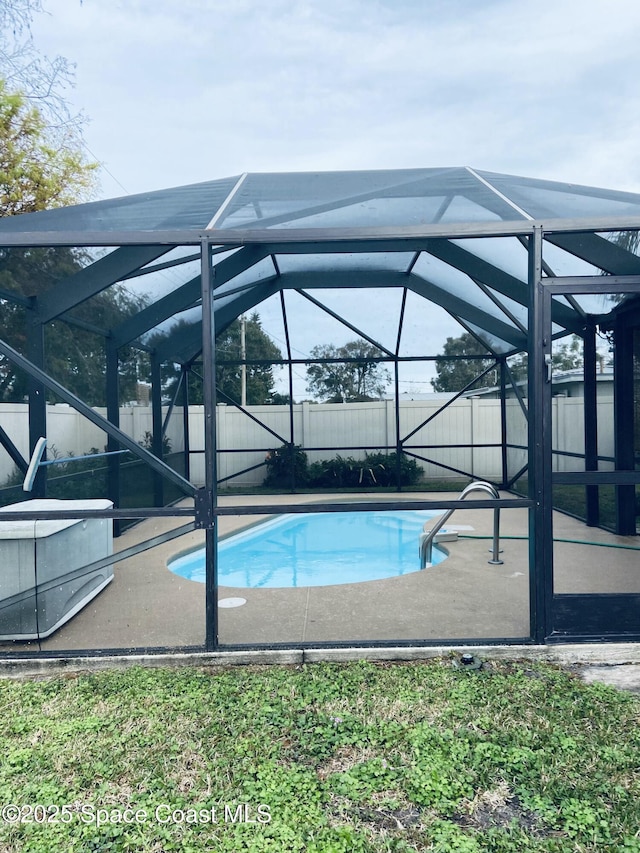 view of swimming pool featuring a patio and glass enclosure