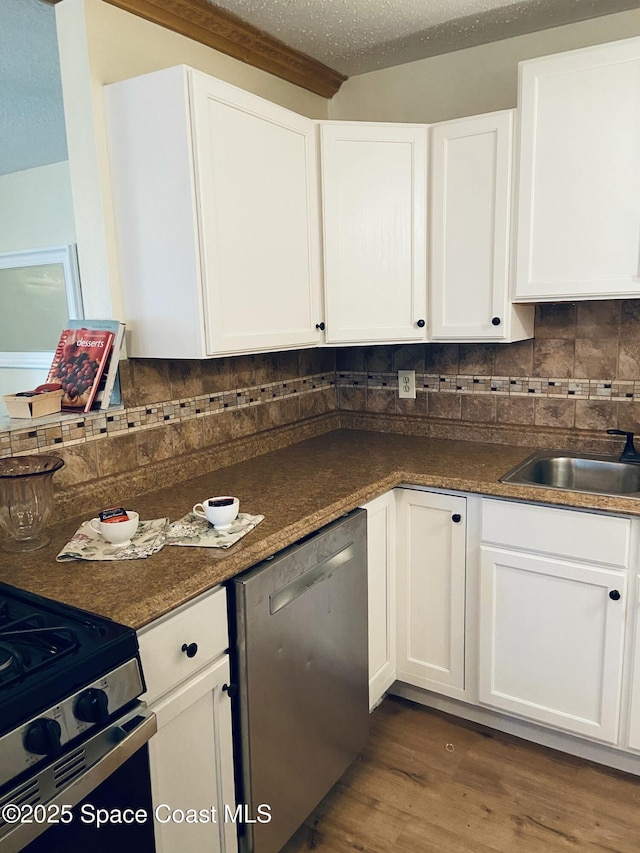 kitchen with sink, dark hardwood / wood-style floors, dishwasher, decorative backsplash, and white cabinets