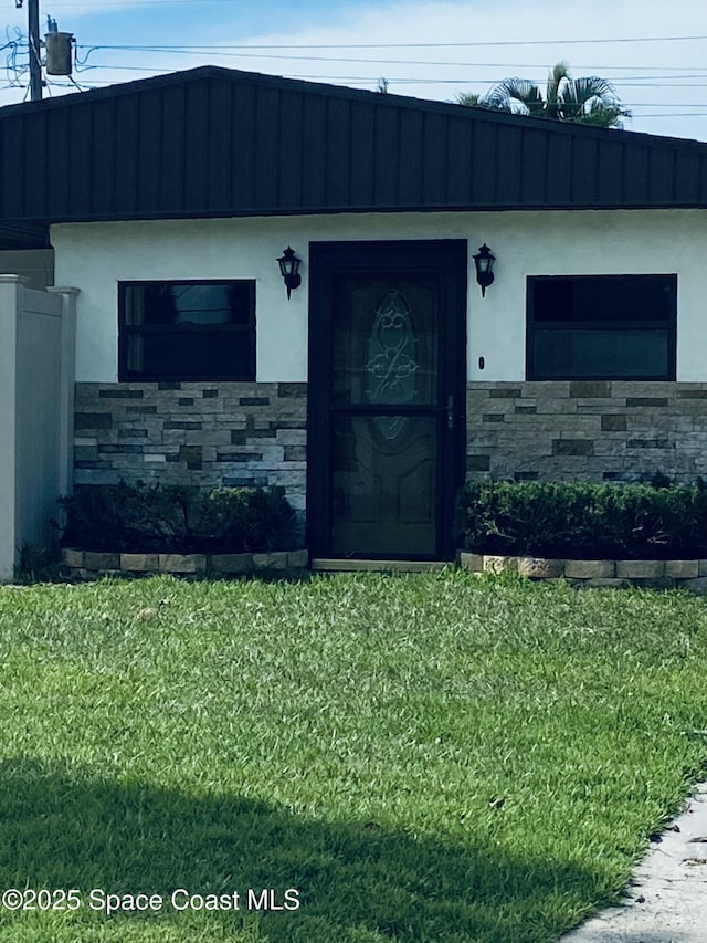 property entrance featuring a lawn