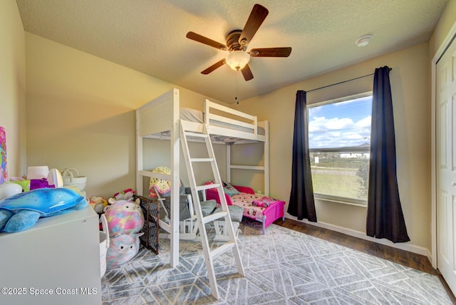 bedroom with ceiling fan, wood-type flooring, a closet, and a textured ceiling