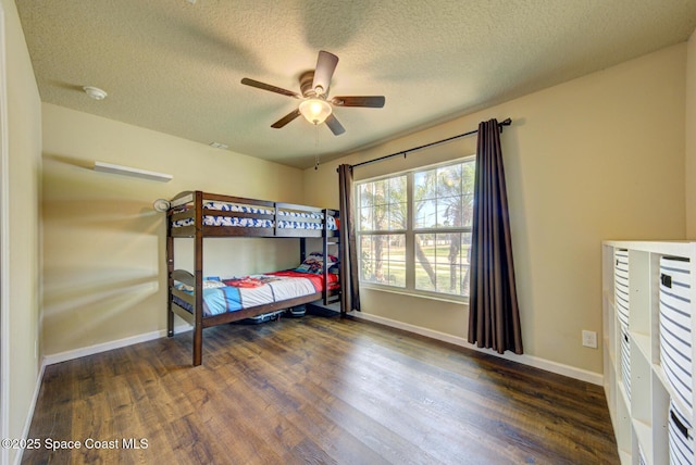 bedroom featuring dark wood-type flooring, ceiling fan, and a textured ceiling