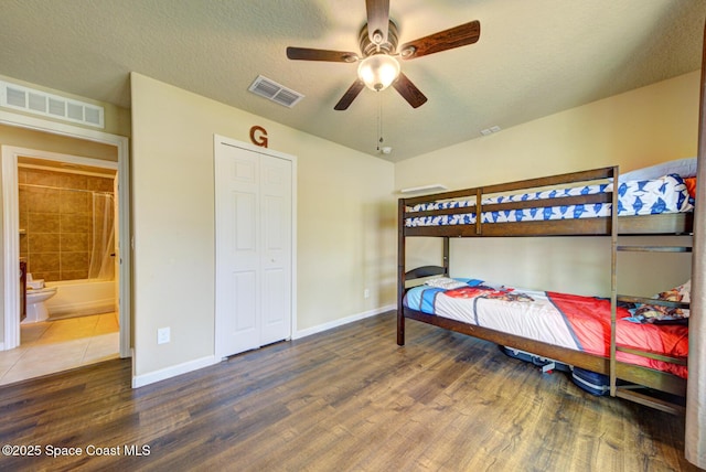 bedroom with ceiling fan, wood-type flooring, and a textured ceiling