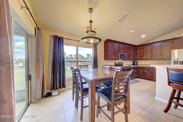 tiled dining space featuring lofted ceiling and a textured ceiling