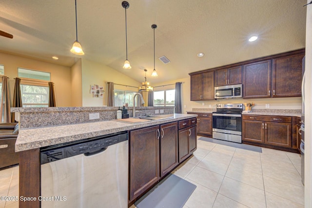 kitchen with an island with sink, sink, hanging light fixtures, dark brown cabinetry, and stainless steel appliances