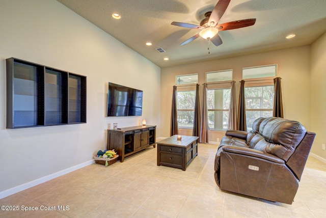 tiled living room featuring ceiling fan and a textured ceiling