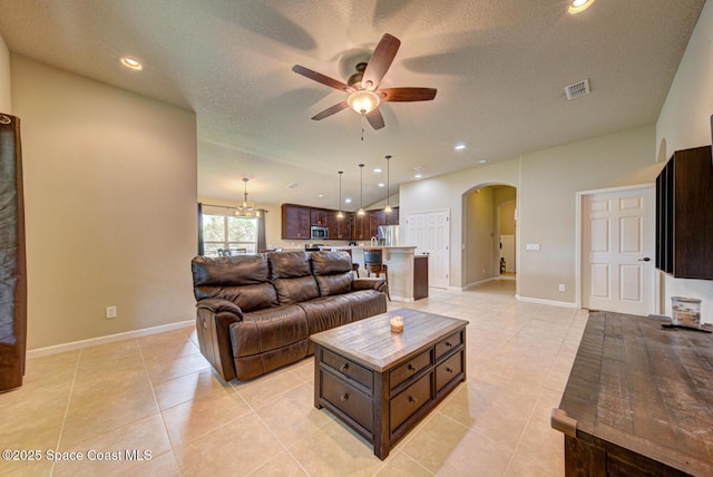 tiled living room featuring a textured ceiling and ceiling fan