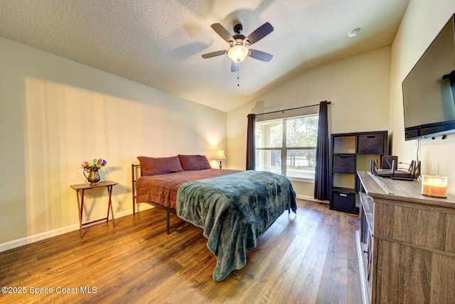 bedroom featuring ceiling fan, lofted ceiling, a textured ceiling, and dark hardwood / wood-style flooring