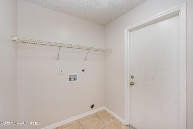 laundry room featuring electric dryer hookup, washer hookup, light tile patterned floors, and a textured ceiling