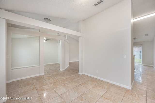 tiled spare room featuring ceiling fan and a textured ceiling