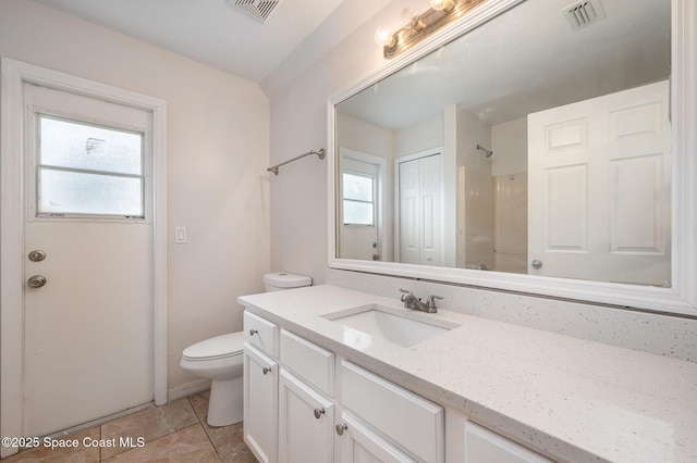 bathroom featuring vanity, tile patterned flooring, a shower, and toilet