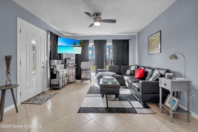 living room with ceiling fan, light tile patterned floors, and a textured ceiling