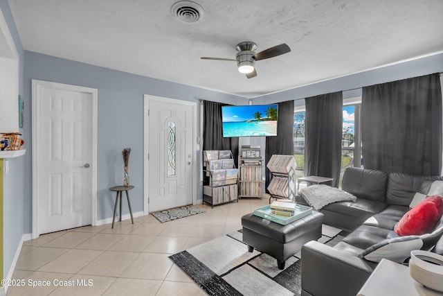 tiled living room featuring ceiling fan and a textured ceiling