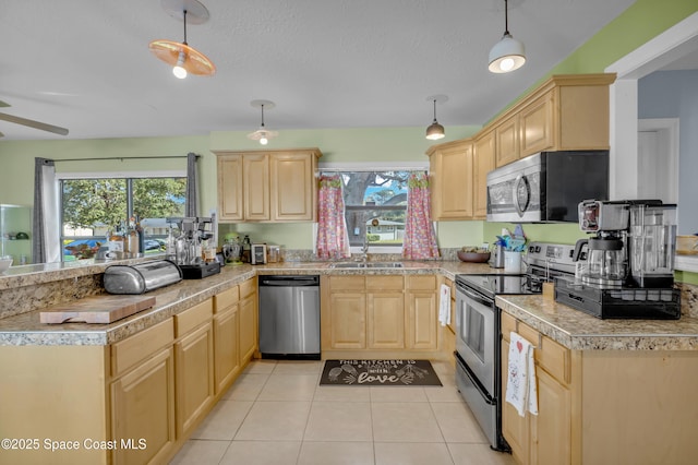 kitchen featuring pendant lighting, light brown cabinetry, light tile patterned floors, stainless steel appliances, and a healthy amount of sunlight