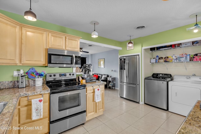 kitchen featuring stainless steel appliances, a textured ceiling, independent washer and dryer, and decorative light fixtures