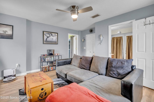 living room with light hardwood / wood-style floors and ceiling fan