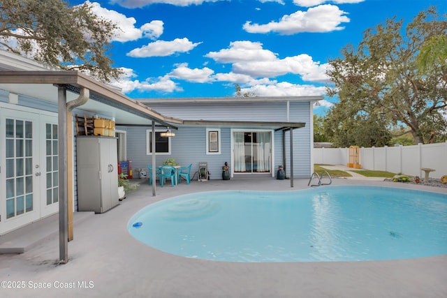 view of swimming pool with a patio and french doors