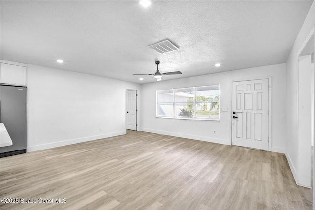 unfurnished living room featuring ceiling fan, a textured ceiling, and light hardwood / wood-style floors