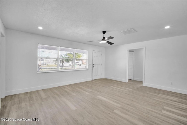 empty room with ceiling fan, a textured ceiling, and light hardwood / wood-style floors