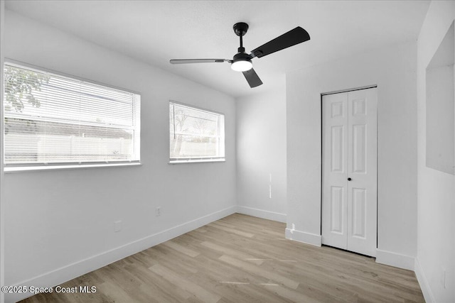 unfurnished bedroom featuring ceiling fan, light hardwood / wood-style floors, and a closet