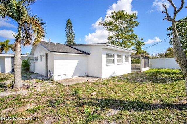 back of property featuring a sunroom and a lawn