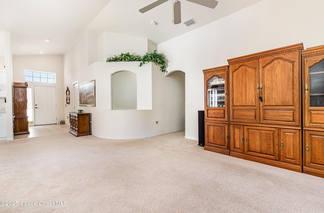 living room featuring visible vents, light carpet, high vaulted ceiling, and ceiling fan