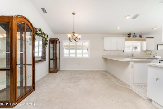 kitchen with visible vents, light carpet, a healthy amount of sunlight, and light countertops