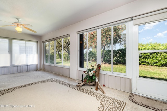 unfurnished sunroom featuring ceiling fan