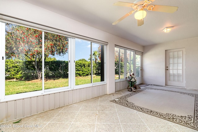 unfurnished sunroom featuring ceiling fan