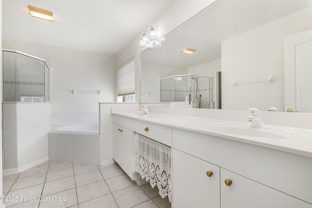 bathroom featuring tile patterned flooring, double vanity, a stall shower, a bath, and a sink