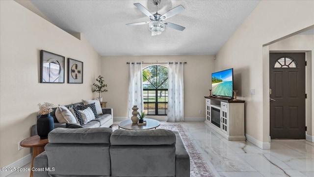 living room with ceiling fan, lofted ceiling, and a textured ceiling