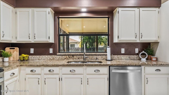 kitchen featuring white cabinetry, sink, stainless steel dishwasher, and light stone counters