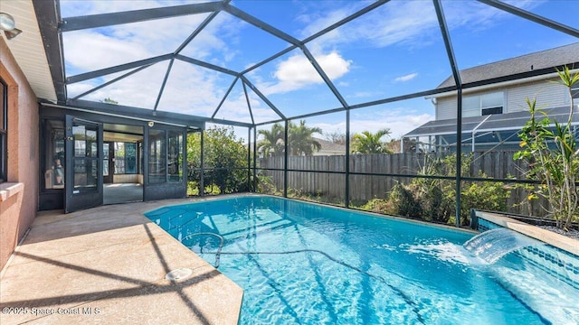 view of pool with pool water feature, a lanai, and a patio