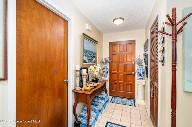 tiled entryway featuring a textured ceiling