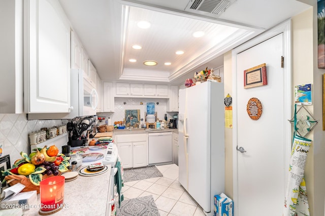 kitchen featuring light tile patterned floors, white appliances, white cabinetry, tasteful backsplash, and a raised ceiling