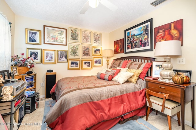 carpeted bedroom featuring ceiling fan and a textured ceiling