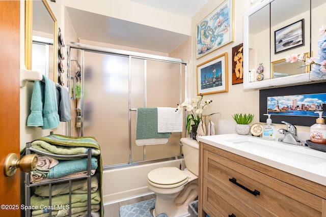 full bathroom with vanity, wood-type flooring, shower / bath combination with glass door, and toilet