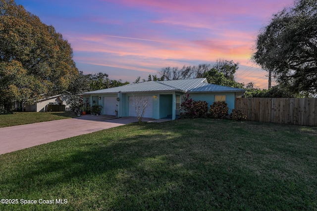 ranch-style home with a garage and a yard