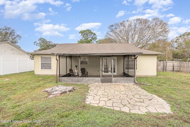 back of house featuring a yard, a patio area, and a sunroom