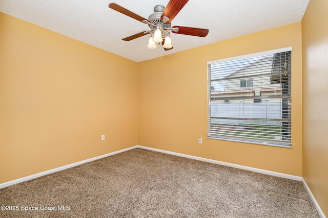 carpeted spare room featuring ceiling fan and a textured ceiling