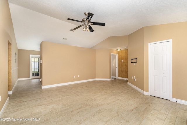 unfurnished room with ceiling fan, light hardwood / wood-style floors, vaulted ceiling, and a textured ceiling