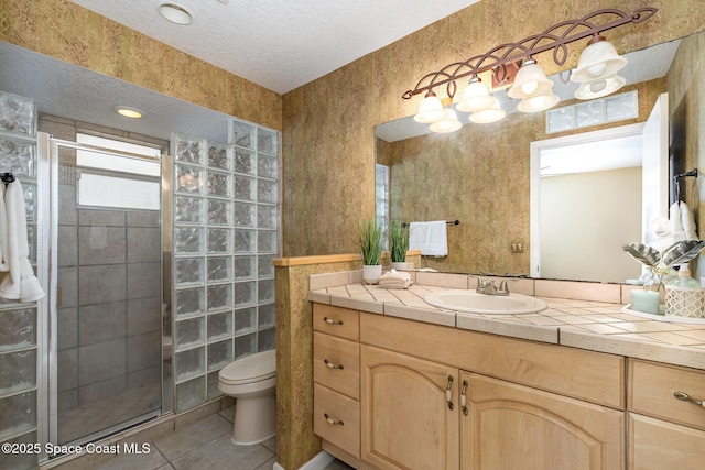 bathroom featuring vanity, an enclosed shower, a textured ceiling, tile patterned floors, and toilet