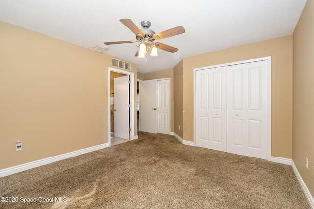 unfurnished bedroom featuring multiple closets, carpet floors, and ceiling fan