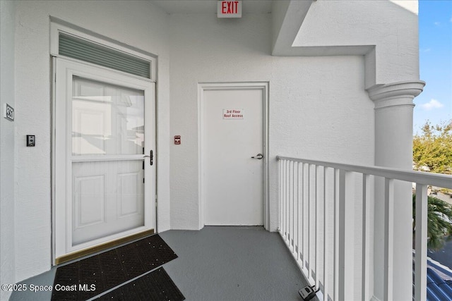 view of exterior entry with a balcony